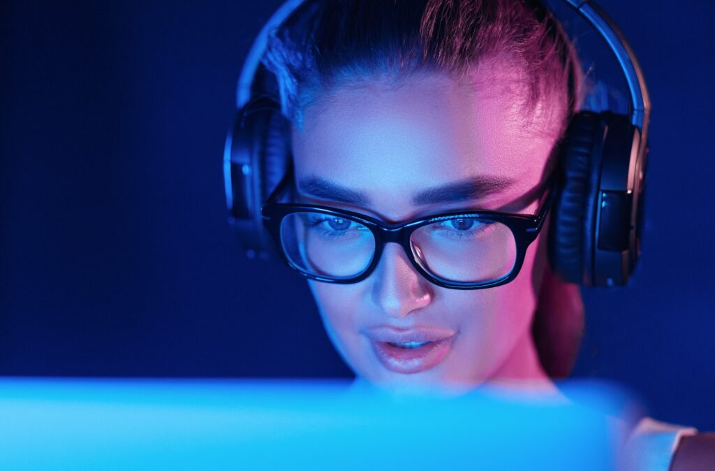 Female pro gamer playing video game, wearing headset